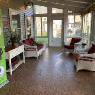 A cozy sunroom with seating and large windows.