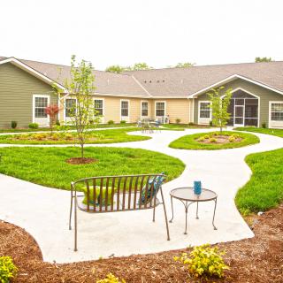 A serene garden with pathways, surrounded by a residential building.