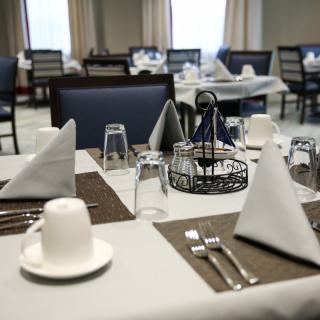 A neatly arranged dining table in a restaurant with glasses, cutlery, and napkins.