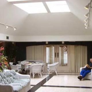 A modern living room with ample natural light from skylights, featuring comfortable seating and contemporary decor.
