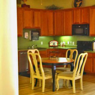 A cozy kitchen dining area with wooden cabinetry and a round table with four chairs.