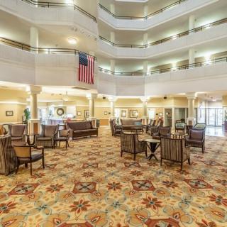 A spacious lobby with an atrium, adorned with elegant furniture and a patterned carpet.