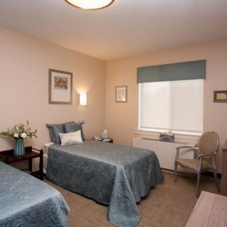 A cozy bedroom with twin beds and soft lighting.