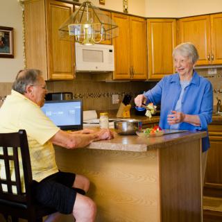 An elderly couple enjoying a moment together in the kitchen.