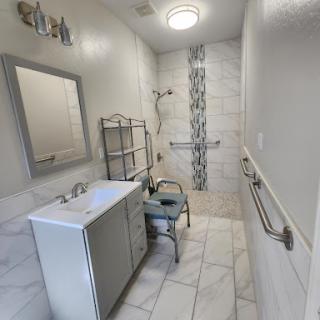 A modern, newly renovated bathroom featuring elegant tile work and accessible fixtures.