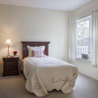Cozy and inviting bedroom with a neatly made bed and natural light.