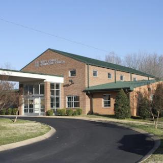 A modern brick building with a welcoming entrance and landscaped surroundings.