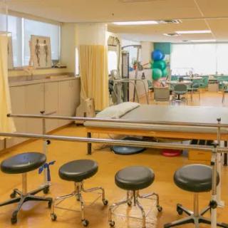 A well-equipped physical therapy room featuring various medical tools and seating arrangements.