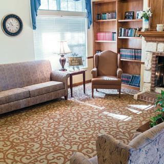 A cozy living room with comfortable seating, a bookshelf, and a fireplace.