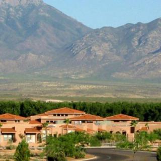 A scenic view of buildings set against a backdrop of mountains and desert landscape.