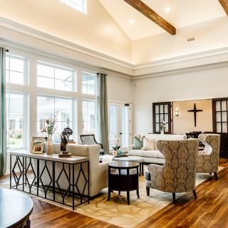 A spacious and elegantly decorated living room with large windows, high ceilings, and modern furniture.