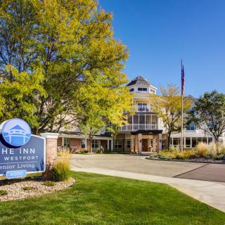 The exterior of The Inn with surrounding trees and a clear blue sky.