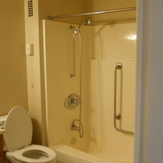 A bathroom with a shower-bathtub combo and a toilet.
