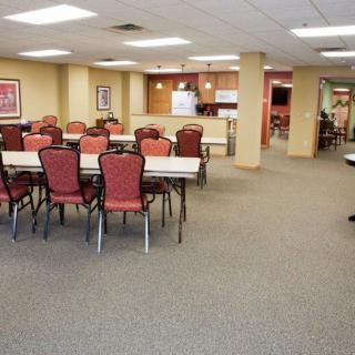 A spacious conference room with multiple tables and chairs, featuring a modern interior design.