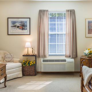 A cozy living room with elegant furnishings and artwork on the walls.