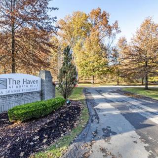 Entrance to a residential area surrounded by autumn trees.
