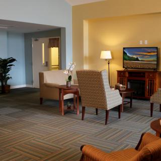 A cozy living room interior with a television, comfortable seating, and warm lighting.
