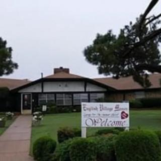 A residential house with a welcome sign in the front yard.