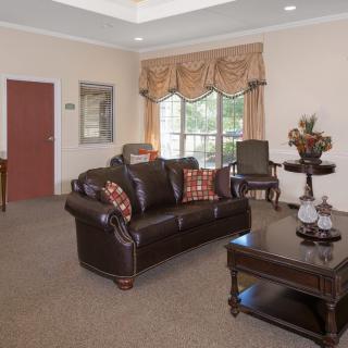 A traditionally decorated living room with a leather sofa, armchairs, and a coffee table.