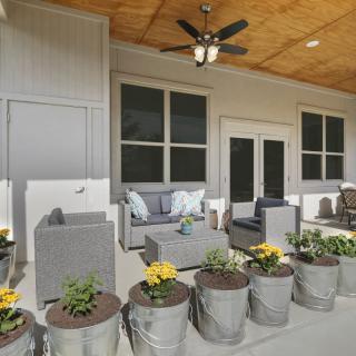A cozy patio with comfortable outdoor seating and decorative flower pots.