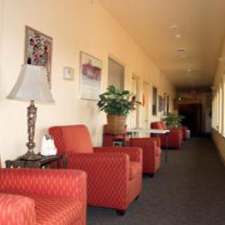 A well-lit hallway with red armchairs and decorative elements.