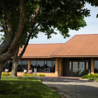 A peaceful view of a brick building surrounded by greenery.