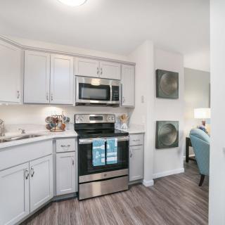 A modern kitchen featuring stainless steel appliances and white cabinetry.
