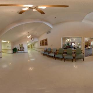 A hospital lobby with a seating area and wide hallway.