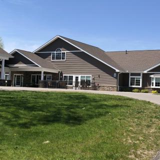 A residential building with a large lawn under a clear blue sky.