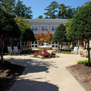 A beautifully landscaped courtyard with a garden and pathway leading to a building.
