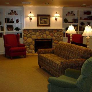 A cozy living room with a fireplace, surrounded by comfortable seating and warm lighting.
