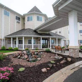 A modern building with landscaped entrance and covered walkway.