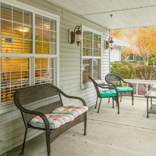 A cozy porch area with comfortable seating and cushions outside a house.