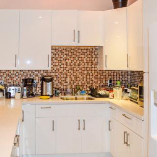 A modern kitchen with white cabinets and a patterned backsplash.