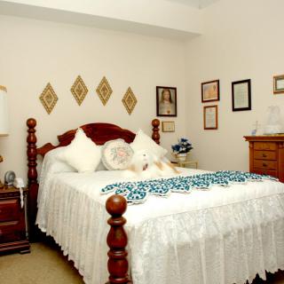 A cozy bedroom with traditional furnishings and decorative wall art.