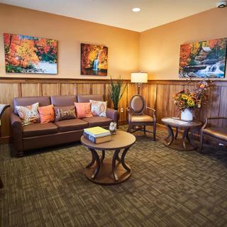 A cozy living room with a sofa, coffee table, and decorative artwork on the walls.