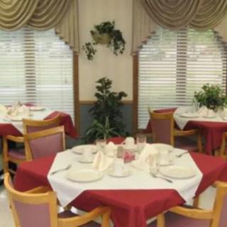 A well-decorated dining room with neatly set tables and elegant curtains.