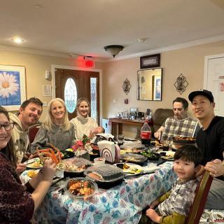 A joyful group of people gathered around a dining table enjoying a meal together at home.