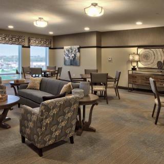 A modern living room featuring comfortable seating, large windows, and tasteful decor.