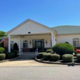 A well-maintained building with a landscaped entrance and clear blue sky.