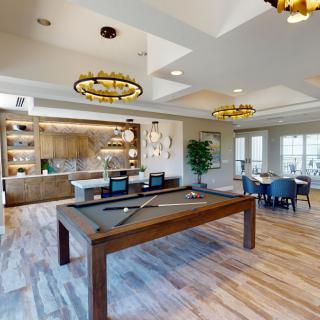 A modern game room featuring a pool table, seating area, and stylish lighting.