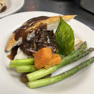 A beautifully plated dish featuring tender meat, vibrant vegetables, and a rich sauce.