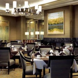 An elegant restaurant dining room with neatly set tables and ambient lighting.
