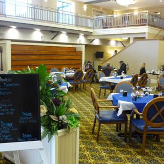 A spacious dining area with neatly arranged tables and a menu board at the entrance.