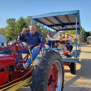 A joyful ride on a classic tractor during a community event.
