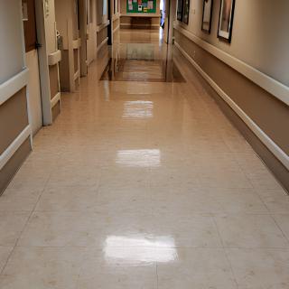 A clean and empty hospital corridor with shiny floors.