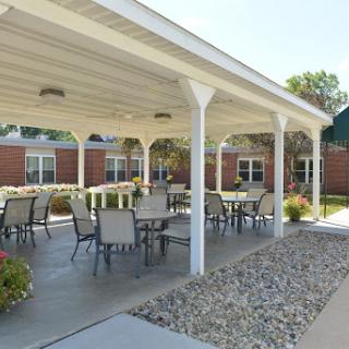 A serene outdoor patio area featuring tables and chairs, perfect for gatherings or relaxation.