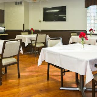 A cozy restaurant dining area with neatly set tables and floral centerpieces.