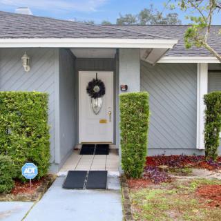 A welcoming home entrance with a wreath on the door and well-maintained hedges.
