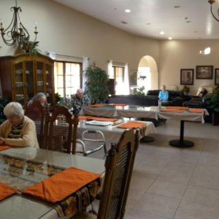 A dining area with seniors seated at tables in a community setting.